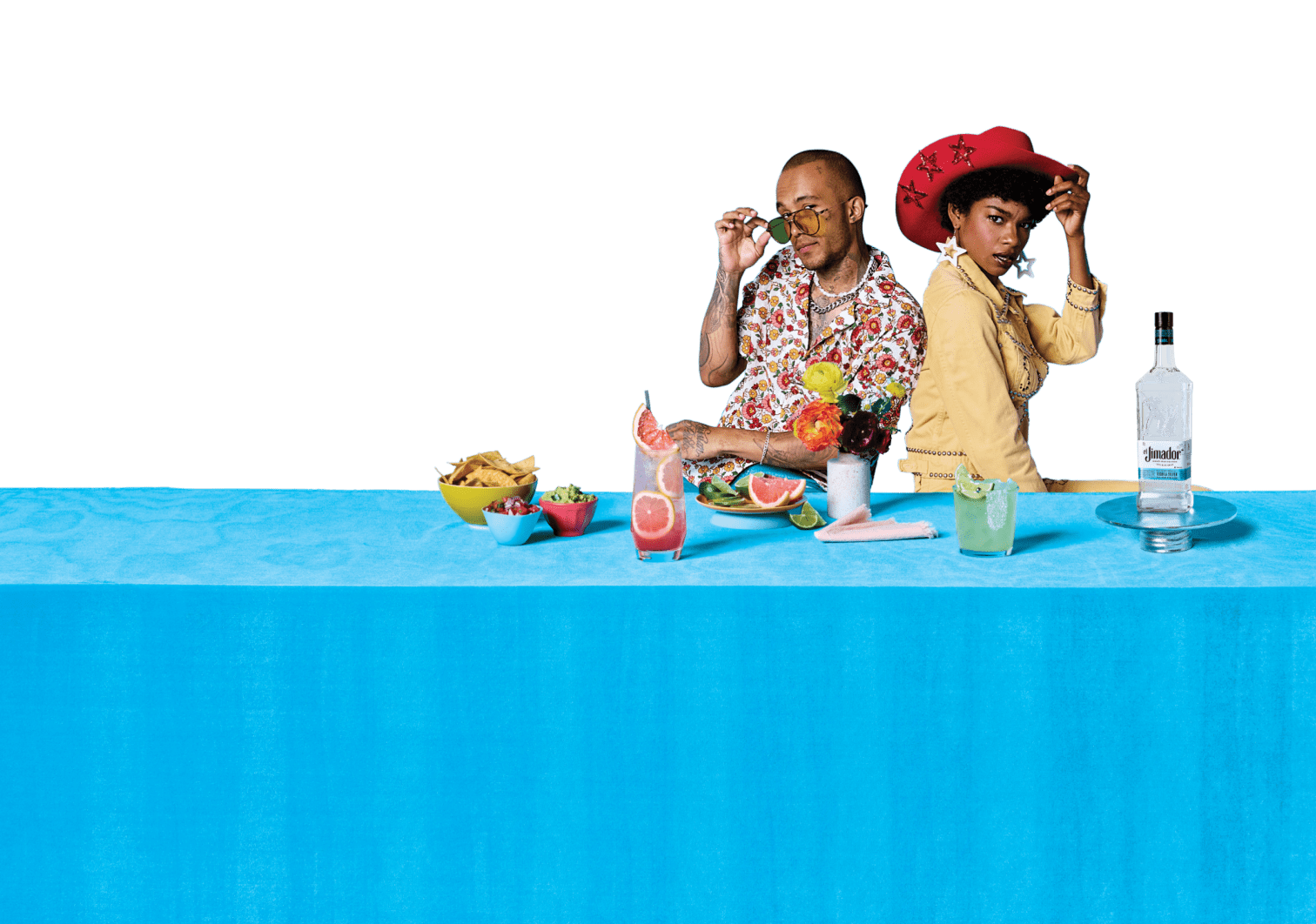 Two friends at a table with cocktails and a bottle of el Jimador Tequila